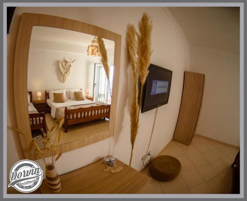 a bedroom with a bed and a large mirror at Dorvin Apartments in Dhërmi