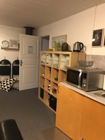 a kitchen with a microwave on a counter and a door at En trappa upp in Malmö