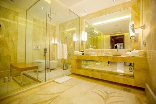 a large bathroom with two sinks and a shower at Grand Millennium Sulaimani in As Sulaymānīyah