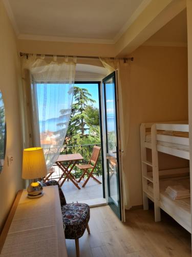 1 dormitorio con 1 cama y balcón con vistas. en Villa Jure - Apartment Mirjana, en Lovran