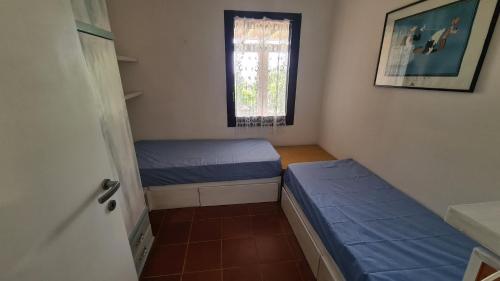 a small room with two beds and a window at Terrazze al Mare (Urlaub an Sardiniens Westküste) in Torre Dei Corsari