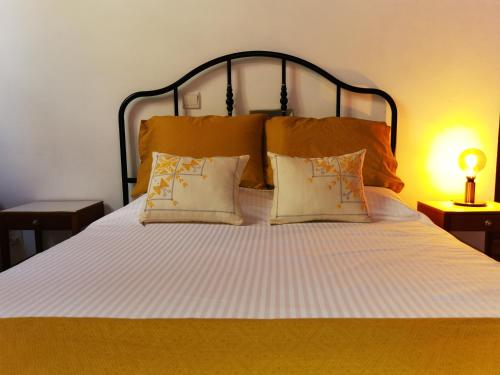 a bedroom with a large white bed with two pillows at 7Kamares in Pano Lefkara