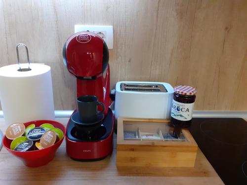 a red coffee maker sitting on a counter next to a container at SunStone Apartment in Zlatibor