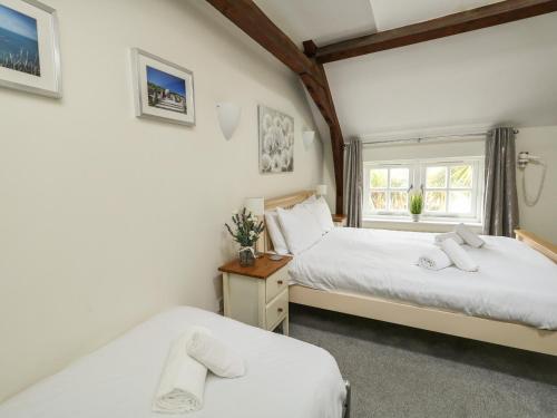 ein Schlafzimmer mit zwei Betten und einem Fenster in der Unterkunft Footprint in Weymouth