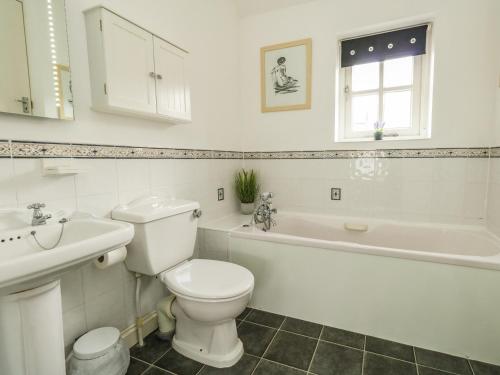 ein weißes Badezimmer mit Toilette und Waschbecken in der Unterkunft Footprint in Weymouth