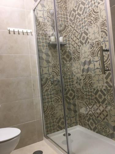 a shower with a glass door in a bathroom at Casa dos Capinha in Caldas da Rainha