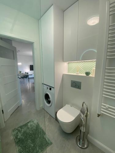 a bathroom with a toilet and a washing machine at Apartament Turystyczna z widokiem na jezioro in Ostróda