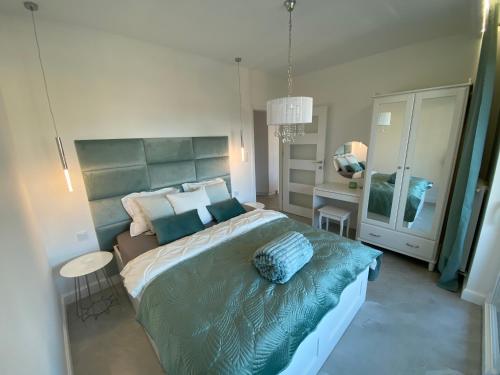 ein Schlafzimmer mit einem großen Bett und einem Tisch in der Unterkunft Apartament Turystyczna z widokiem na jezioro in Ostróda
