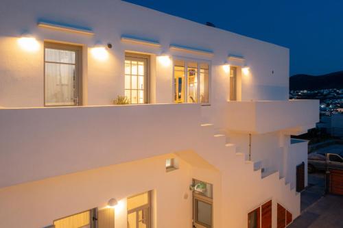 una casa con paredes blancas y escaleras por la noche en The Be House en Sifnos