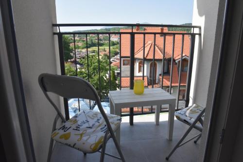 a balcony with a table and chairs and a view at Millenium apartment in Soko Banja