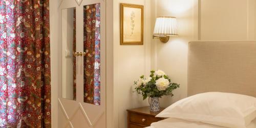 a bedroom with a vase of flowers next to a door at Despotiko Hotel in Mýkonos City