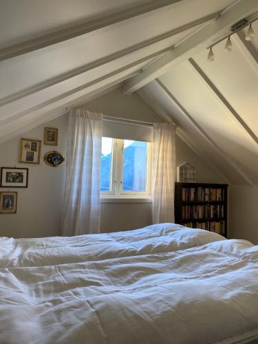 a bedroom with a white bed and a window at Indreli feriehus in Flåm