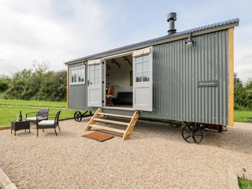 a green shipping container with a table and chairs at Ridgeway in Faringdon