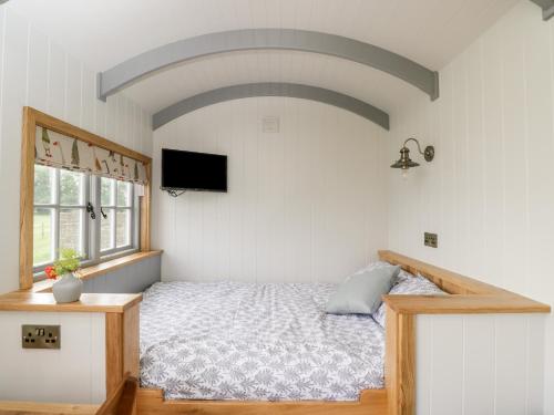 a bedroom with a bed and a television in it at Ridgeway in Faringdon
