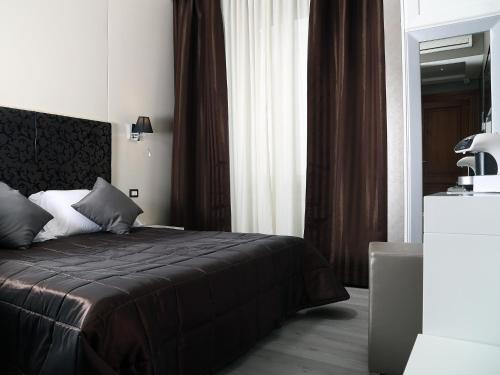 a bedroom with a bed with a black comforter at Piccolo di Piazza di Spagna Suites in Rome