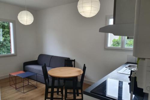 a living room with a table and a couch at Modern Apartment Near The Sea in La Teste-de-Buch