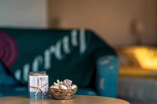 a table with a glass jar and a basket of seashells at Къщички Синьо лято, Черноморец - Варна - Blue Summer Houses Varna in Varna City