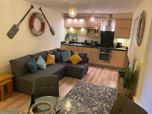 a living room with a couch and a kitchen at Saltwater Apartment in Filey