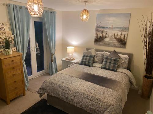 a bedroom with a bed and a painting on the wall at Saltwater Apartment in Filey