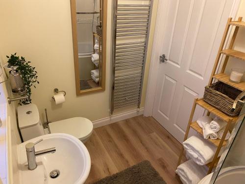 ein Badezimmer mit Waschbecken, Toilette und Spiegel in der Unterkunft Saltwater Apartment in Filey