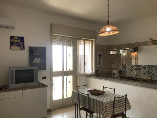 シャッカにある2 bedrooms appartement at San Giorgio Timpirussi 400 m away from the beach with sea view enclosed garden and wifiのキッチン(テーブル、椅子、テレビ付)