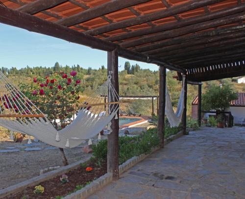 a couple of hammocks hanging from a pergola at Monte Pinheiro in Rabaços