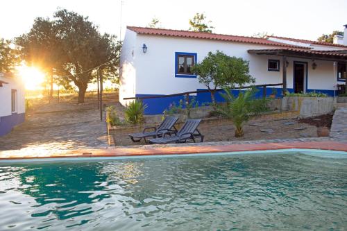 a house and a swimming pool in front of a house at Monte Pinheiro in Rabaços