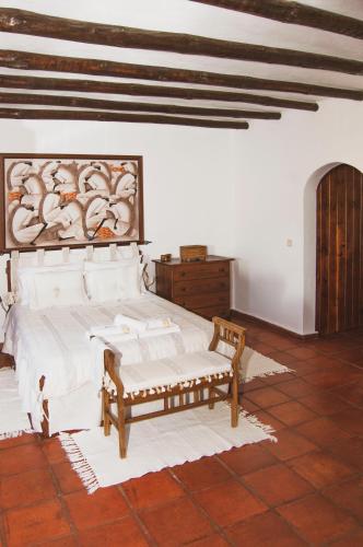 a bedroom with a bed and a bench in it at Monte Pinheiro in Rabaços