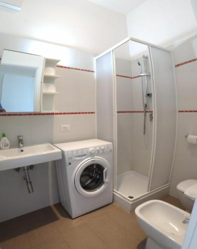 a bathroom with a washing machine and a sink at Big Sabaudia in Sabaudia