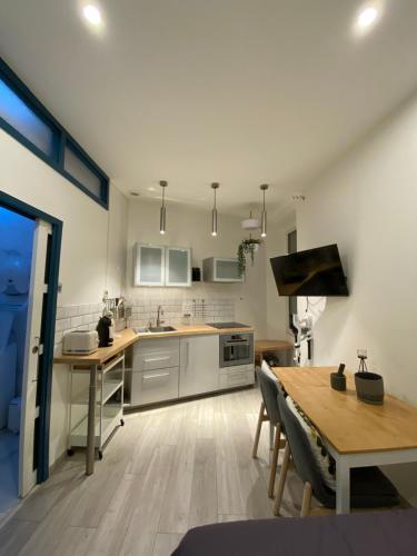 a kitchen with a wooden table and a dining room at MRTN APARTMENTS Studio & Suites - Aix-les-Bains, hypercentre in Aix-les-Bains