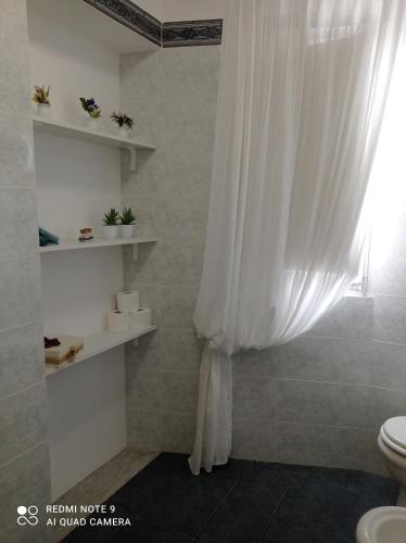 a bathroom with a white shower curtain and a toilet at Cappuccini Green Relax in Carini