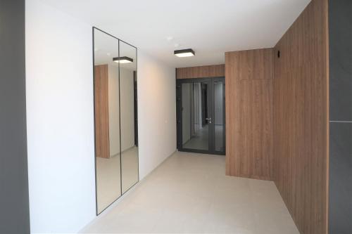 a hallway with glass doors and a mirror at HoliApart in Nautikka Park - blisko plaży, kids club, plac zabaw, garaż podziemny in Krynica Morska