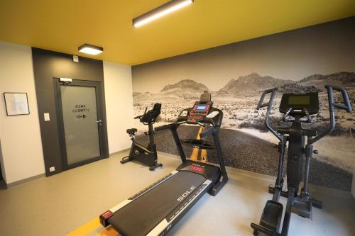 a gym with two tread machines and a wall mural at HoliApart in Nautikka Park - blisko plaży, kids club, plac zabaw, garaż podziemny in Krynica Morska