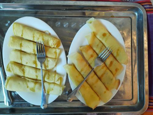 a plastic tray with two white plates and silver forks at Hakuna Matata homestay Mai Châu in Mai Chau