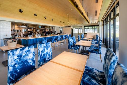 a restaurant with blue chairs and tables and a bar at UNO HOTEL in Tamano