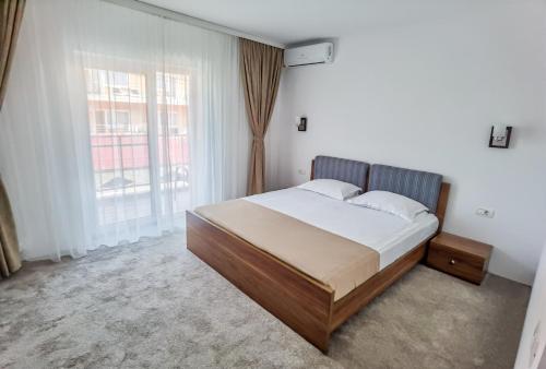 a bedroom with a bed and a large window at Vila Kalliopi in Eforie Nord