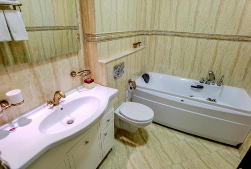 a bathroom with a sink and a tub and a toilet at Vila Kalliopi in Eforie Nord
