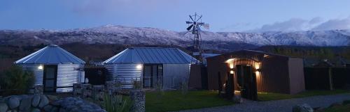 a small observatory with a windmill and mountains in the background at River Rock Estate in Cromwell