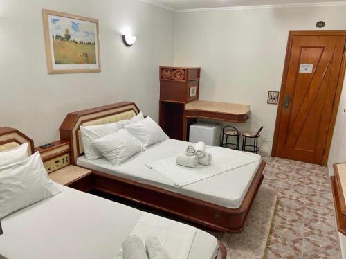a small bedroom with two beds and a desk at Paissandú Palace Hotel - Próximo às ruas 25 de Março, Sta Ifigênia e regiões do Brás e Bom Retiro in Sao Paulo