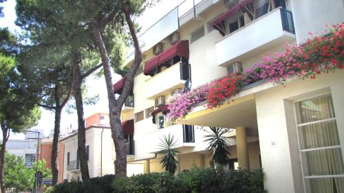 un edificio con flores a un lado. en Hotel New Primula, en Rímini