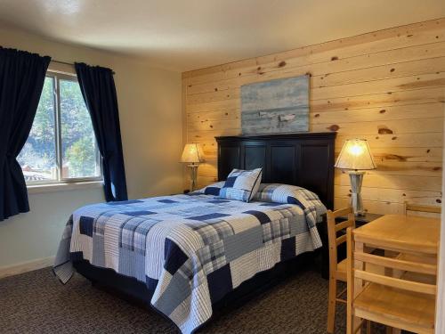 a bedroom with a bed and a wooden wall at Mountain View Lodge & Cabins in Hill City