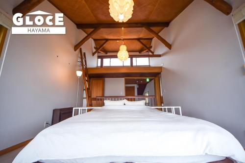 a bedroom with a white bed and a chandelier at GLOCE 葉山 Ocean View House 都心から1時間 湘南の絶景を独り占めペットok 出張BBQ有り in Yokosuka
