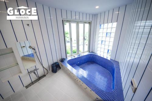 a blue tub in a bathroom with a window at GLOCE 葉山 Ocean View House 都心から1時間 湘南の絶景を独り占めペットok 出張BBQ有り in Yokosuka