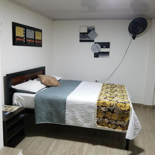 a bedroom with a bed and a clock on the wall at Hotel La Posada in Belén de Umbría