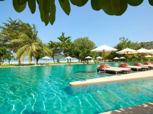 a swimming pool with chairs and umbrellas at PP Princess Resort in Phi Phi Islands