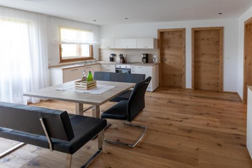 a kitchen and dining room with a table and chairs at Innermoarhof in Rifiano