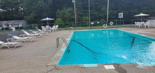 a blue swimming pool with chairs at Red Ranch Inn in Catskill