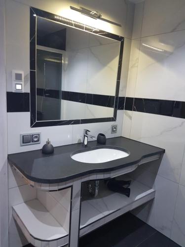a bathroom with a sink and a large mirror at Domek Shrek in Boszkowo