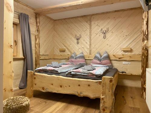 a bedroom with a bed in a log cabin at Alpengasthof Hirschbichlalm in Zellberg