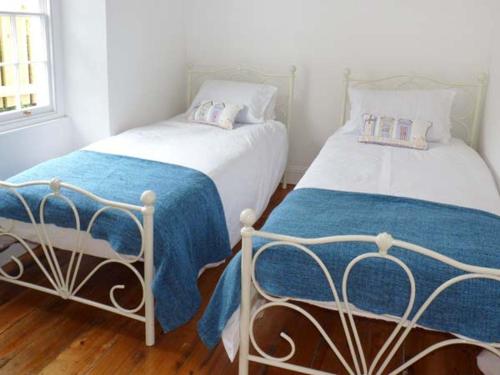 two beds sitting next to each other in a room at Rose Cottage in St Austell